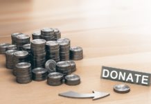 Why is a Charitable Lead Annuity Trust the ideal vehicle for Estate Planning, Income Tax Planning and charitable giving? Piles of coins symbols on a wooden table and an arrow pointing a single coin with the word donate. Donation concept. 3d illustration.