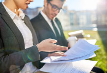 How Business Executives Can Set and Meet Their Estate Planning Goals Business people discussing documents at meeting