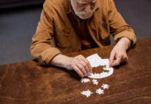 Incapacity Planning – The Other Part of Estate Planning high angle view of senior man playing jigsaw puzzle as dementia therapy